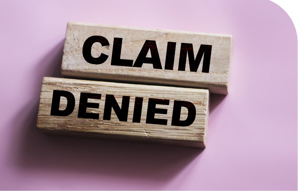 Wooden blocks spelling "Claim Denied" on a purple background